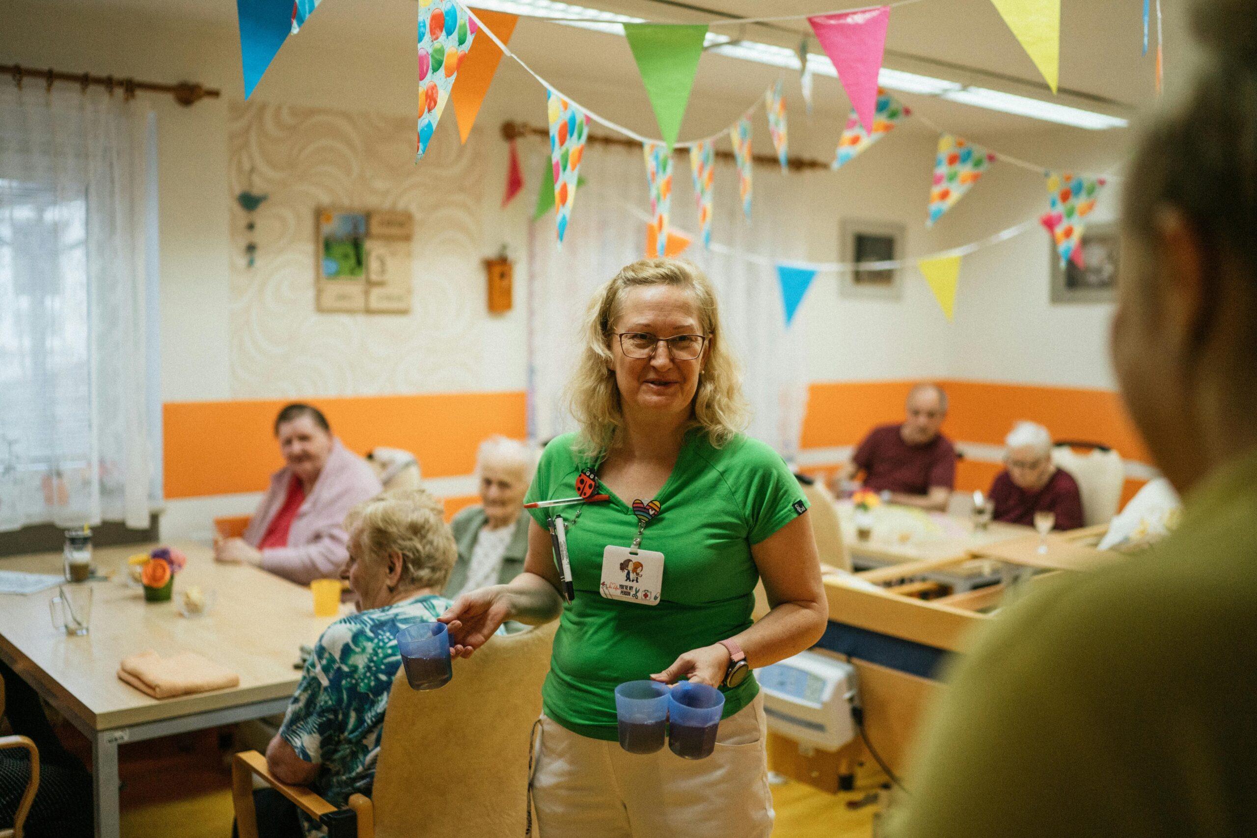 Verzorgster in gesprek met bewoners in een VVT-locatie